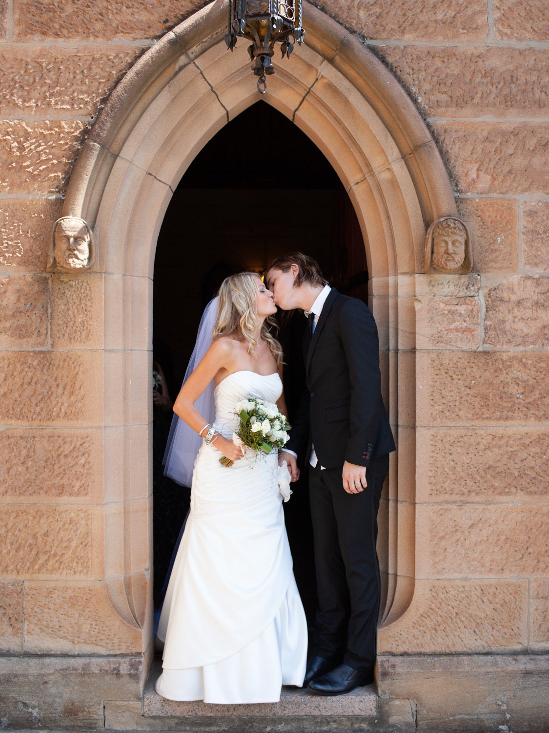 Couple kissing at St Marks Anglican Church Darling Point entrance