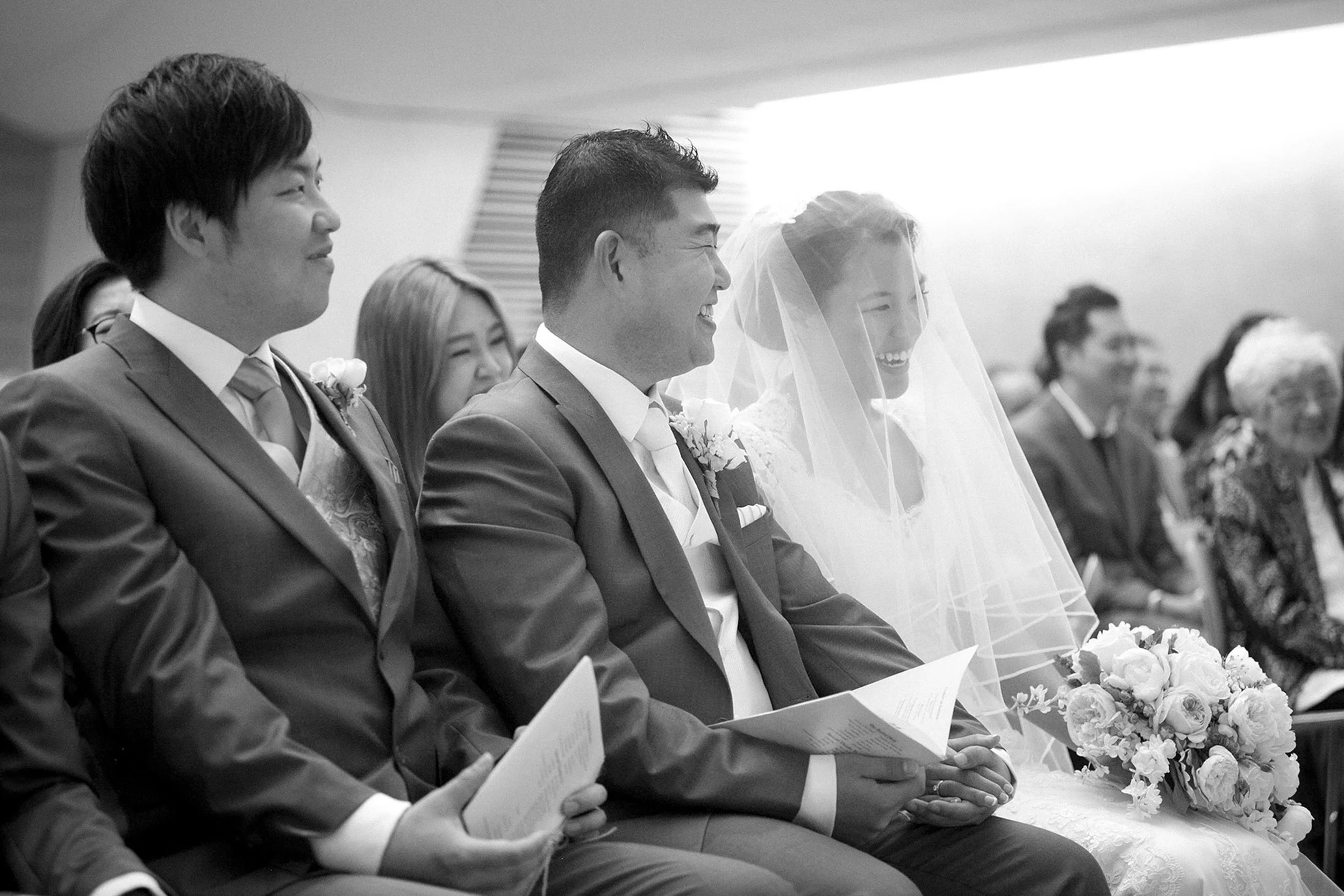 Bride and groom smiling during marriage sermon St Barnabas Broadway Ultimo Sydney wedding black and white