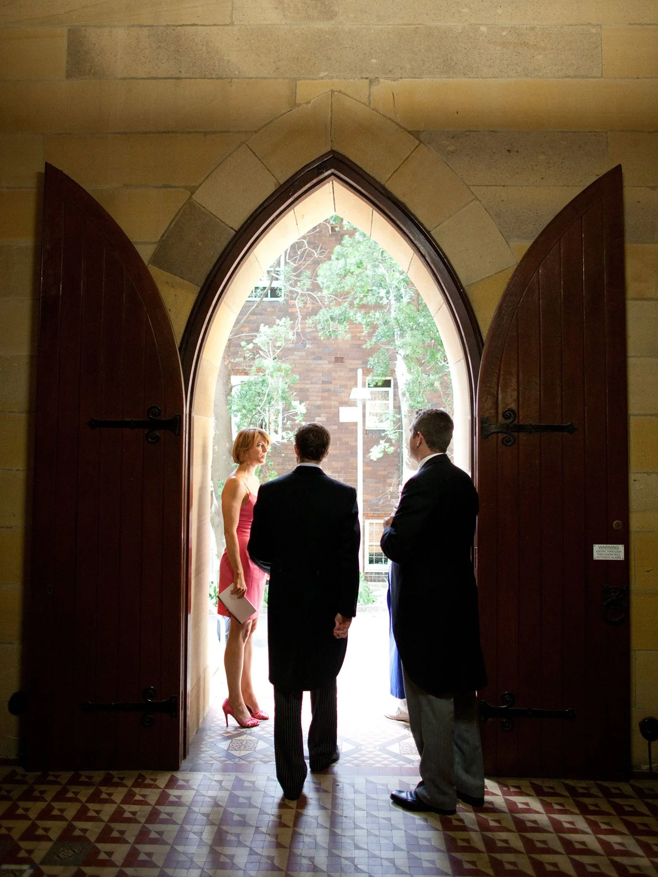 Bride and groom silhouetted in the arched doorway of All Saints Anglican Church Woollahra