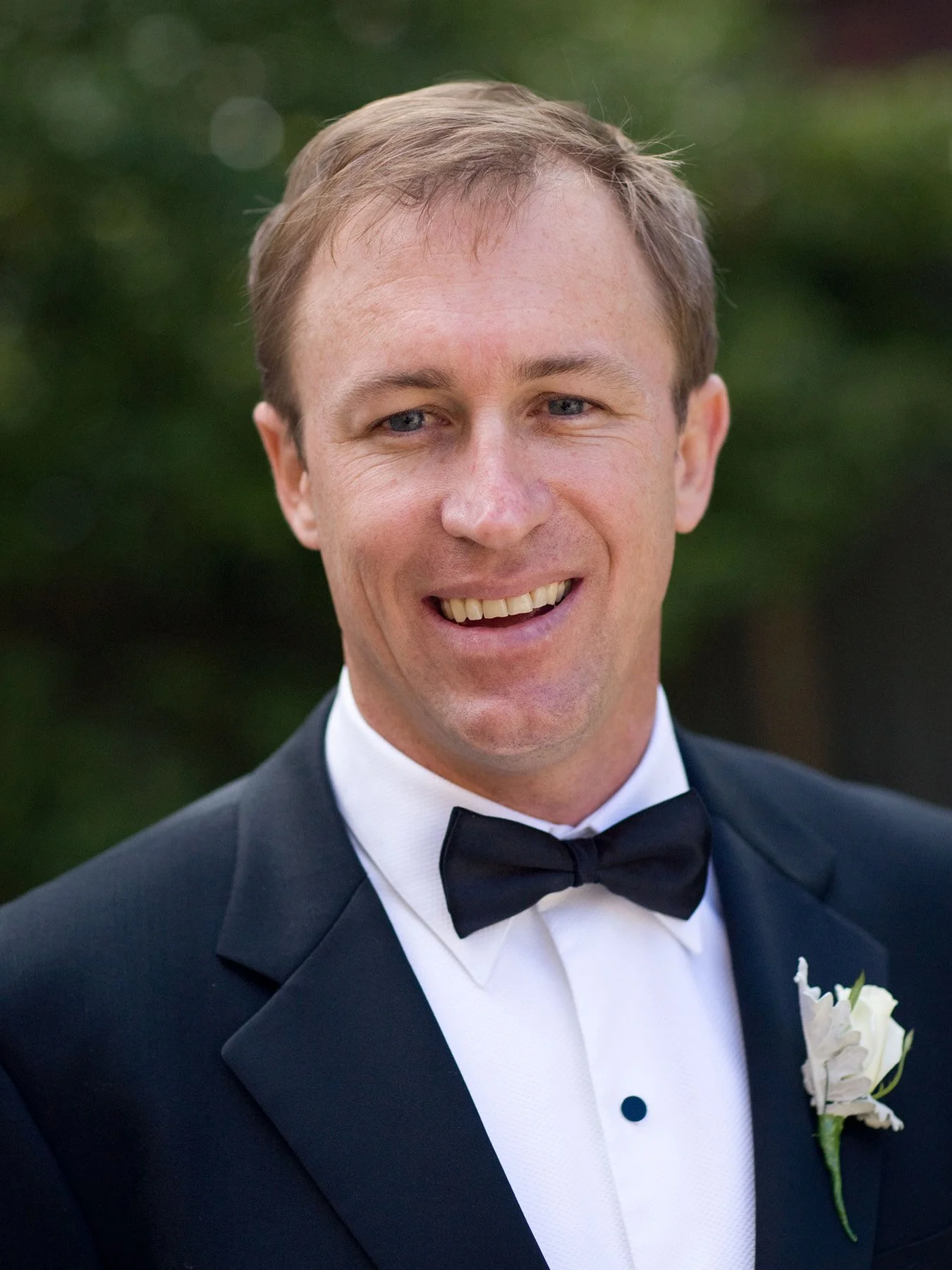 Groom in black tie smiling before the ceremony at All Saints Anglican Church Woollahra
