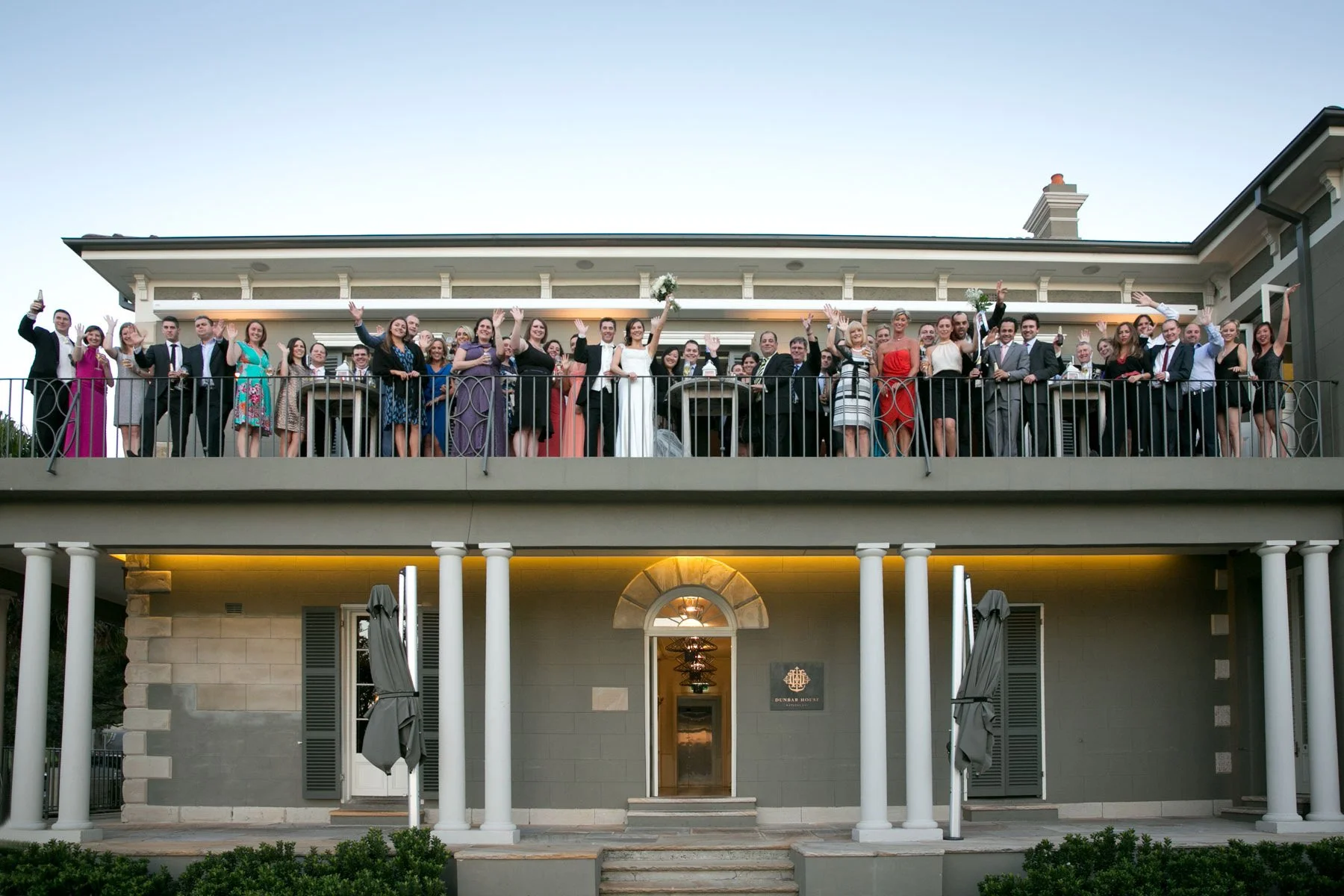 sydney-wedding-photography-dunbar-house-exterior-guests-waving.jpg