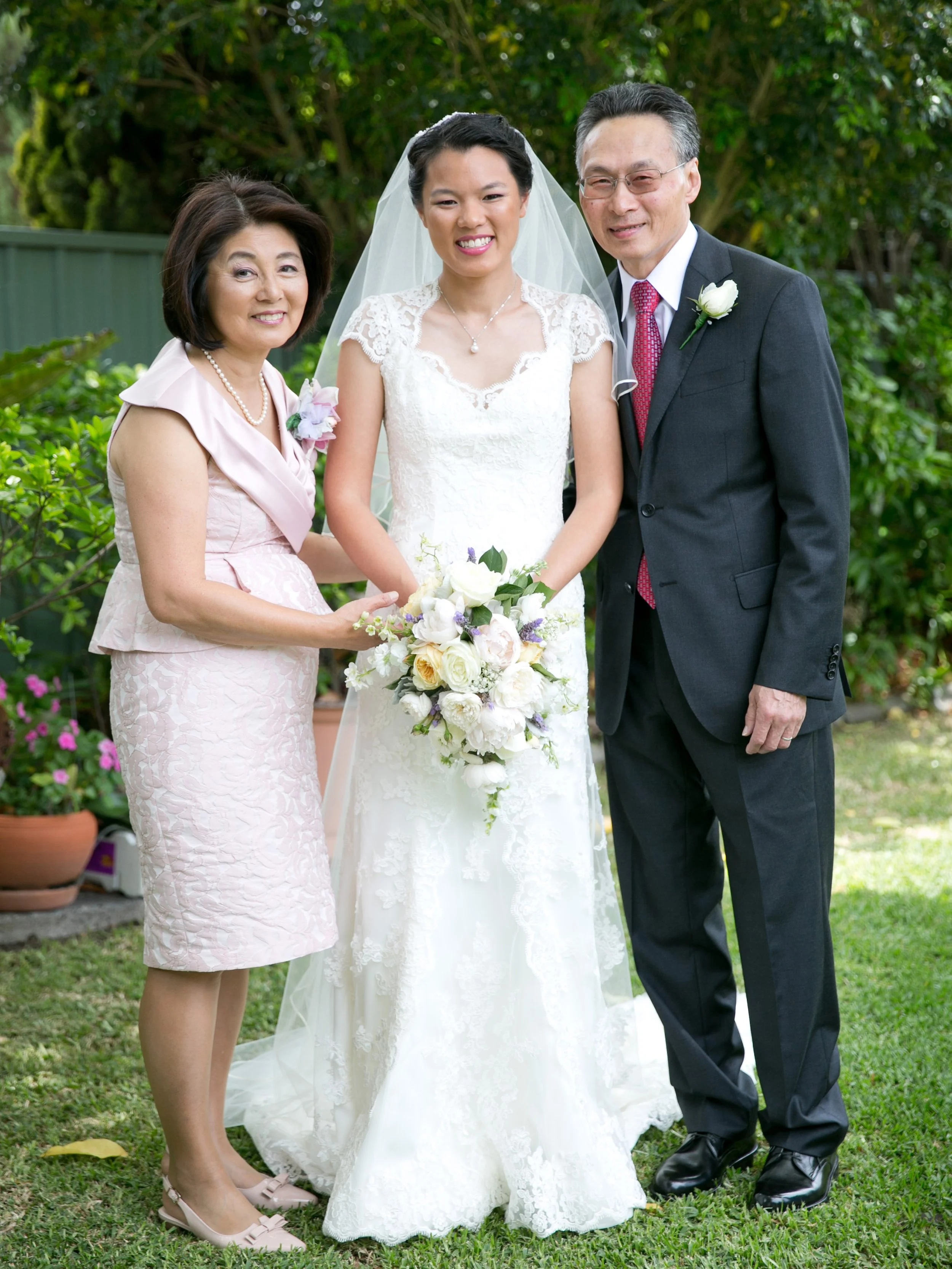 Backyard garden portrait of bride with her parents