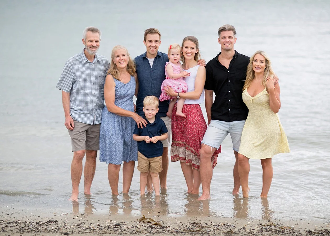 Three generations of family standing at beach