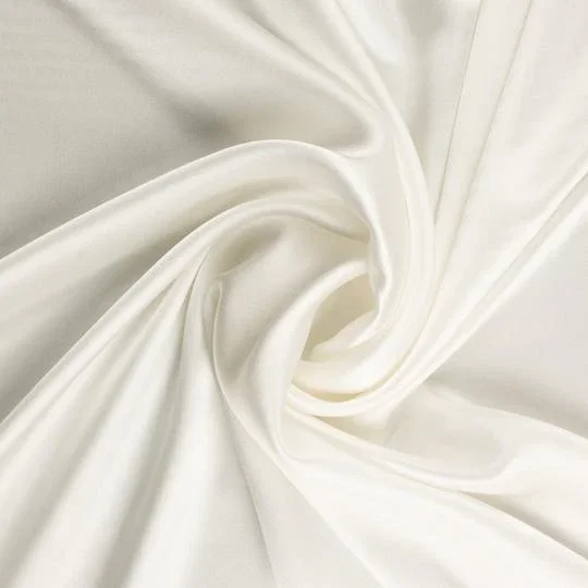 Close-up of smooth, white satin fabric with gentle folds.