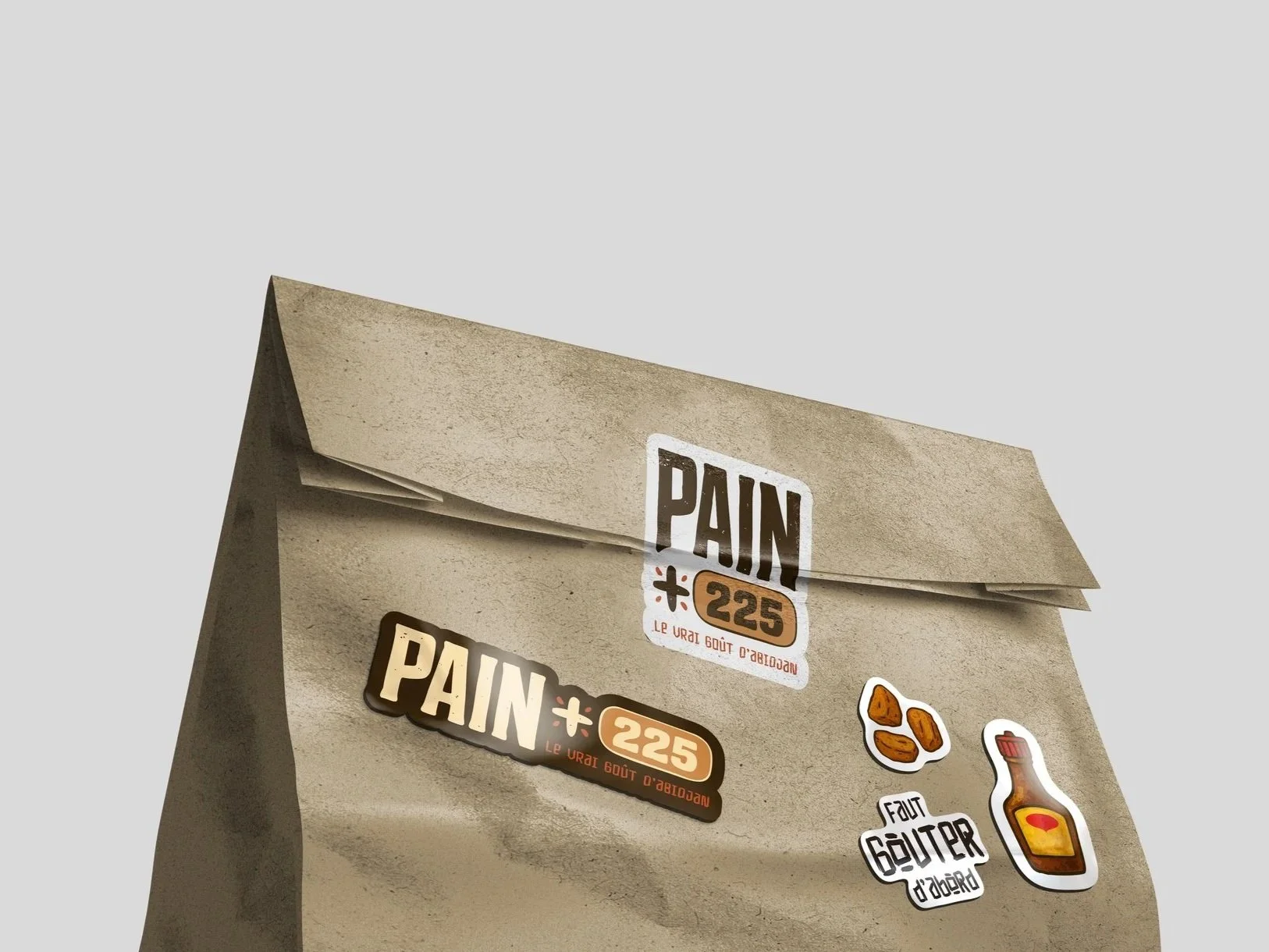 Brown kraft PAIN 225 paper bag with branded stickers.
