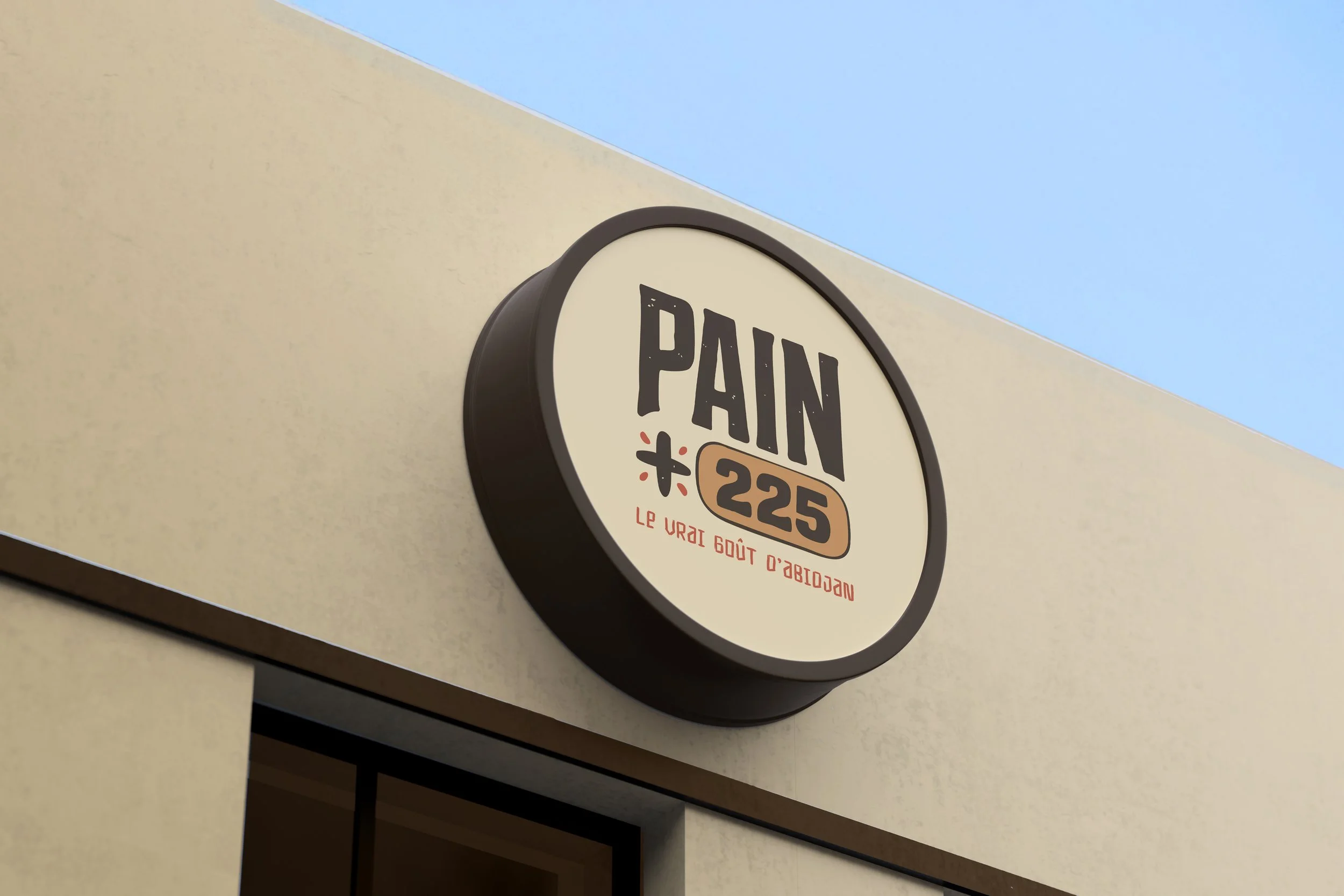 PAIN 225 round storefront sign mounted on a beige building.