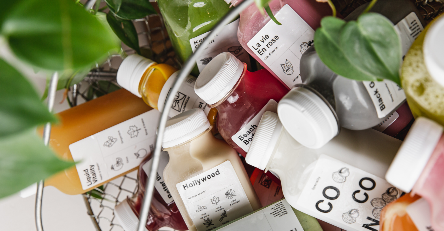 Basket of cold-pressed juice bottles with printed labels.