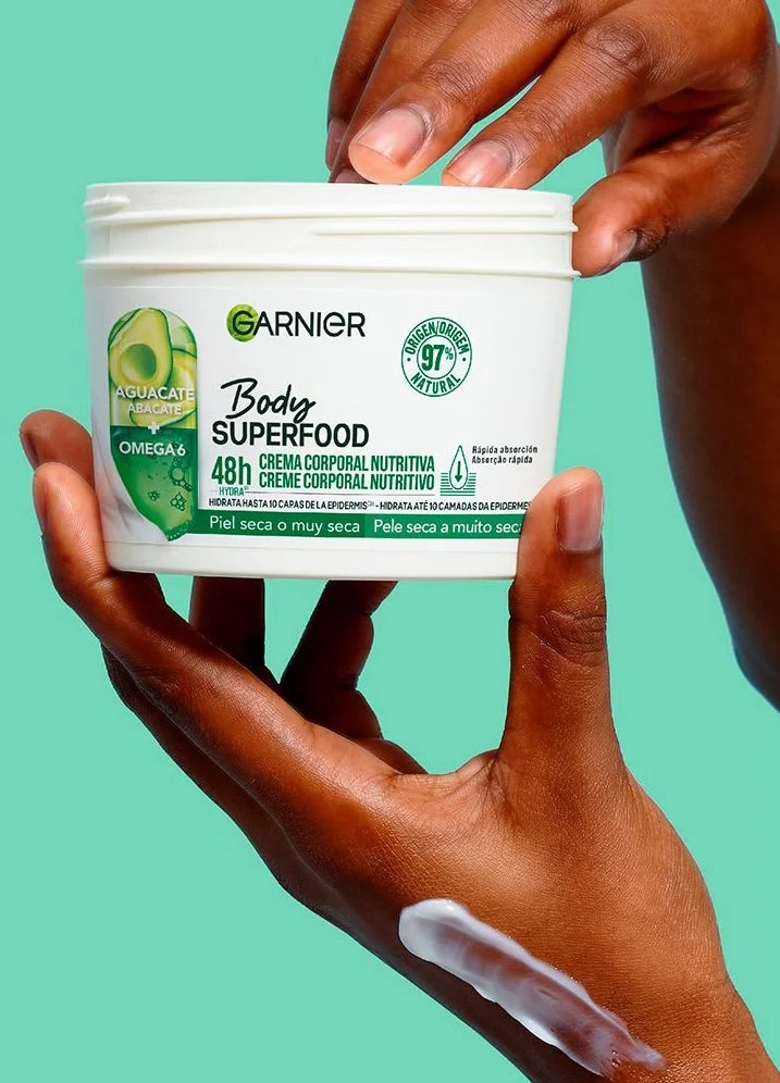Hands holding Garnier Body Superfood cream.
