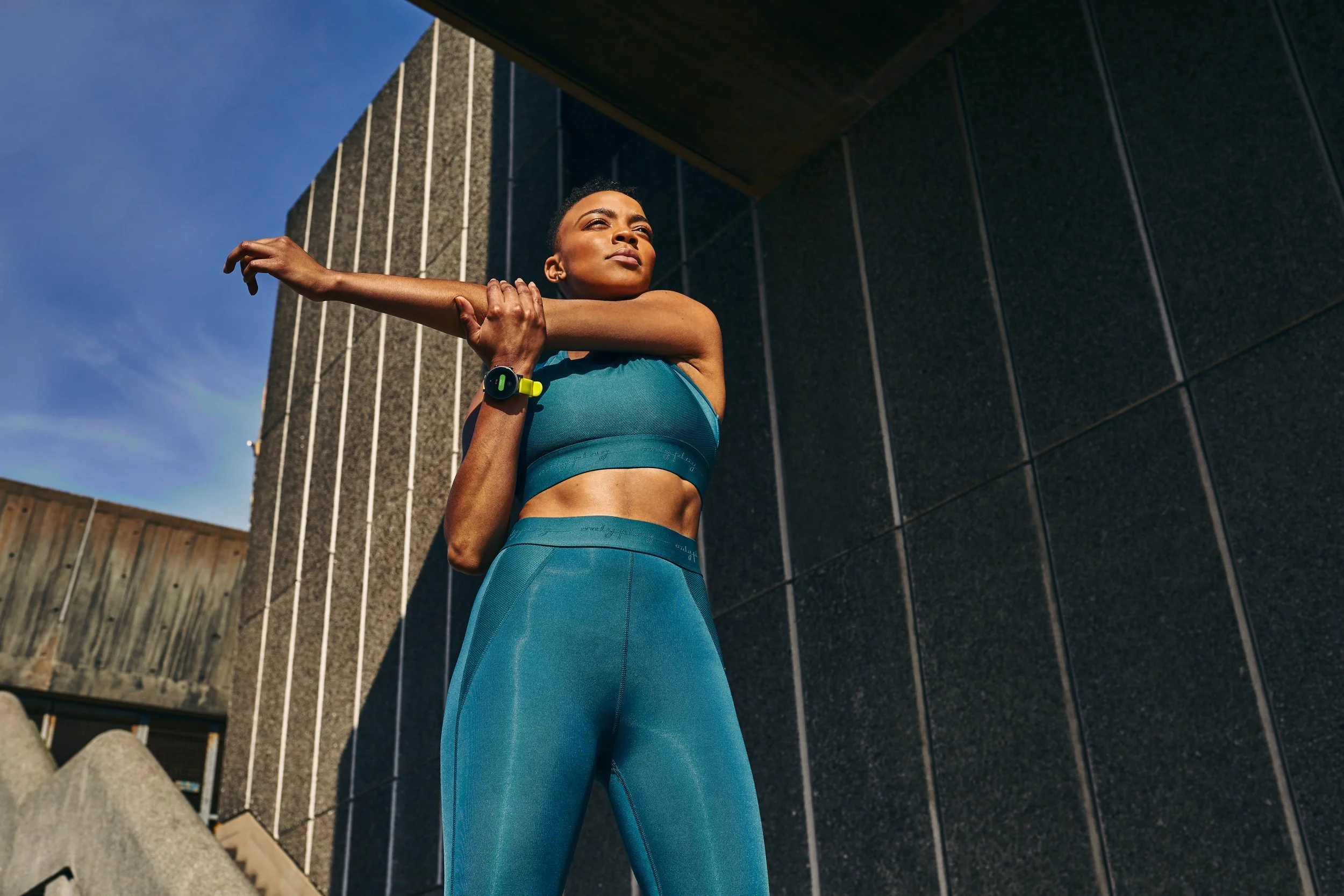 A women exercises in the city using her smart watch. Lifestyle image by sports advertising photographer Jon Enoch.