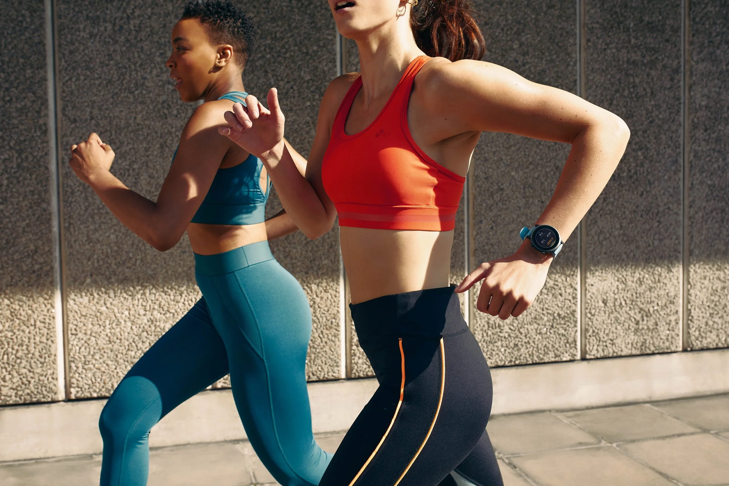 Two women run along the streets of London wearing sportswear and smart watches in this lifestyle photography shot for technology brand Mobvoi by lifestyle photographer Jon Enoch.