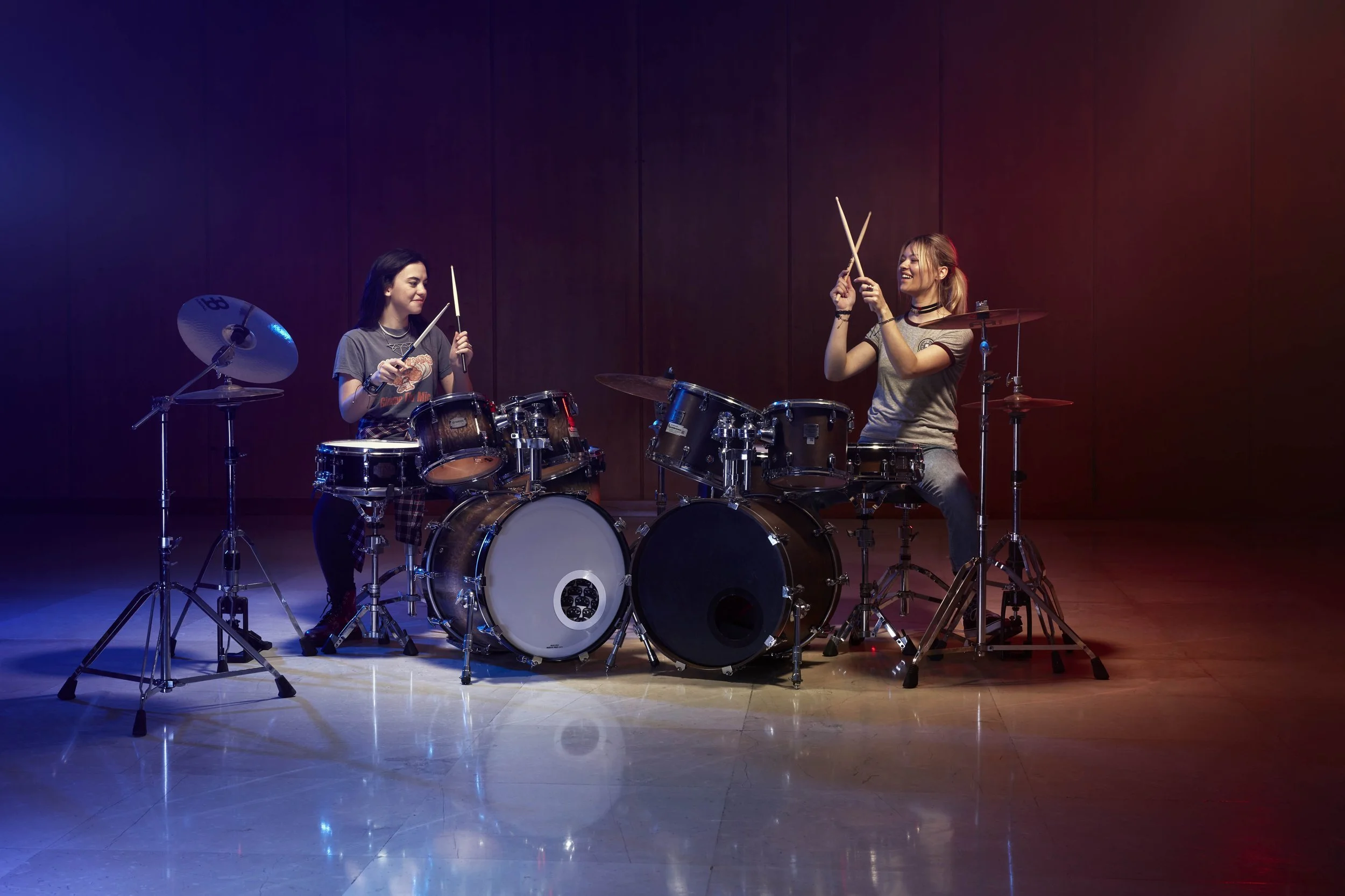 Two drummers sit at two drum kits in this advertising image by Jon Enoch