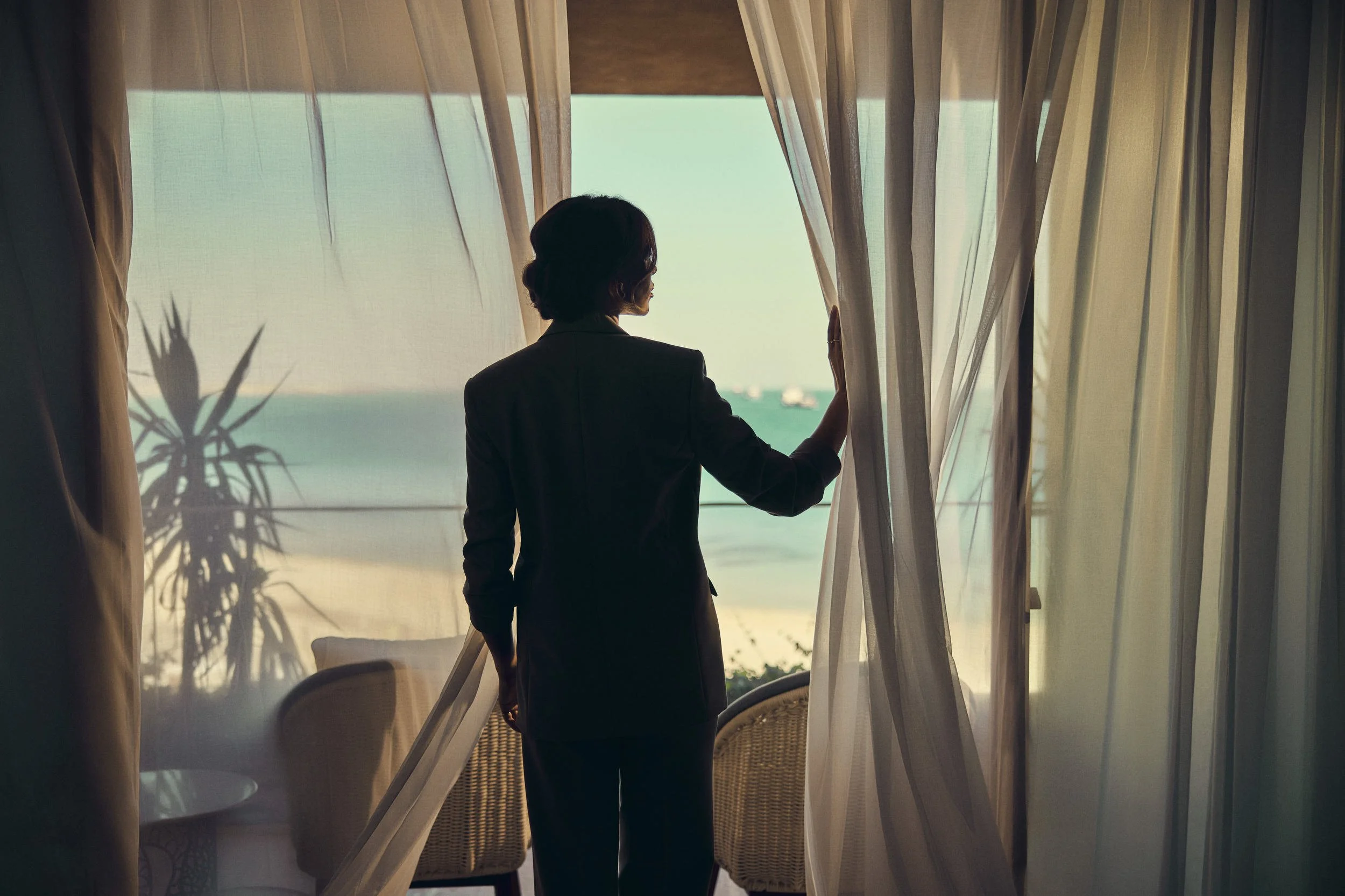 A young women looks out of her hotel room in this lifestyle images shot for the Saudi Neom project featuring their Red Sea luxury holiday island