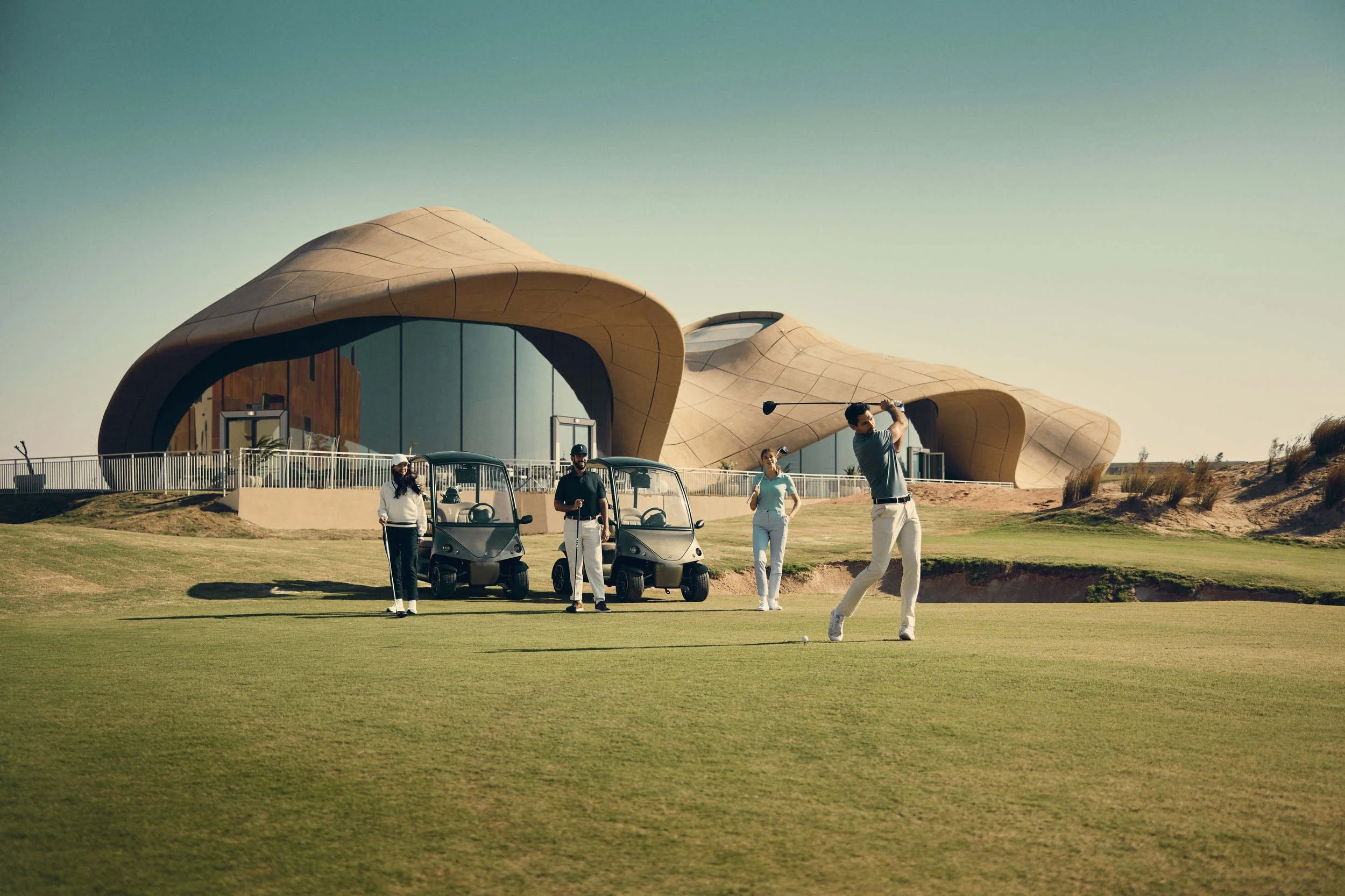 A group of friends play golf in this lifestyle image shot for the Saudi Neom project featuring their Red Sea luxury holiday island