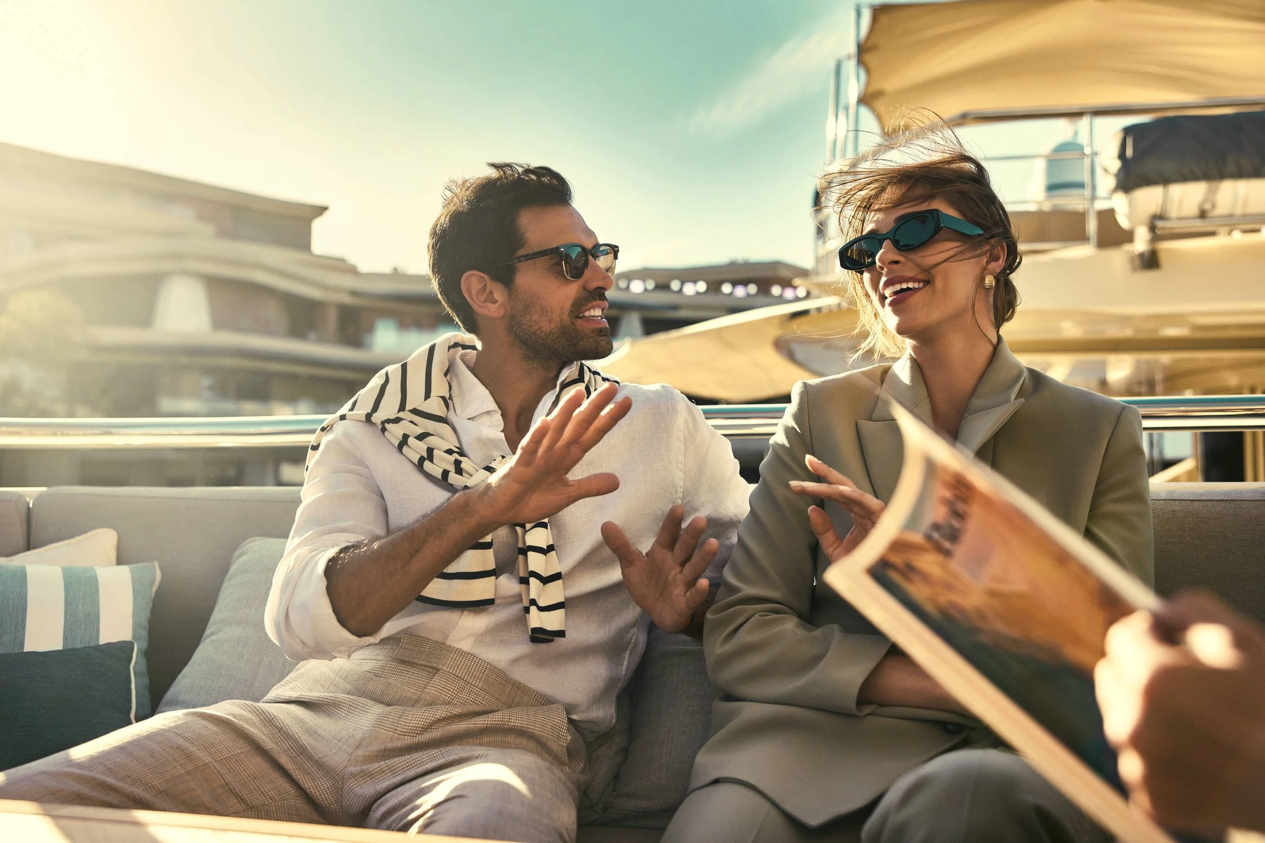 friends chat whilst they sit onboard a luxury yacht in this lifestyle image shot for the Saudi Neom project featuring their Red Sea luxury holiday island