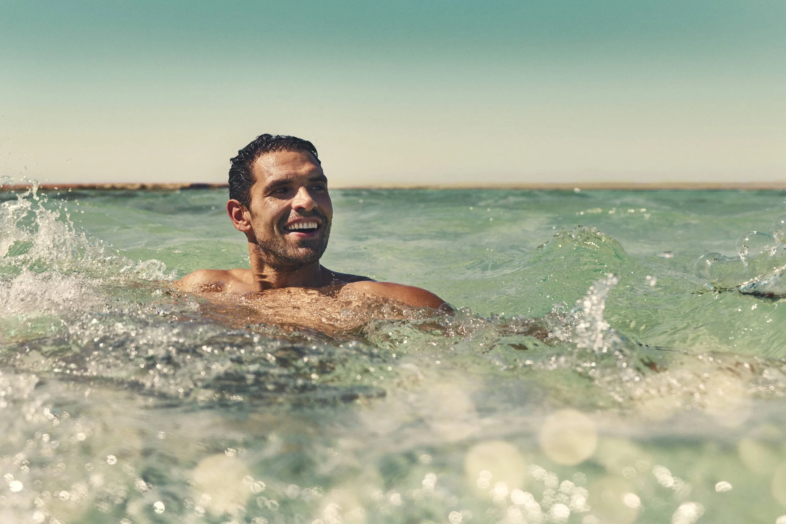 A guest enjoys a swim in the Red Sea in this lifestyle image taken for the Saudi Neom project's Sindalah island
