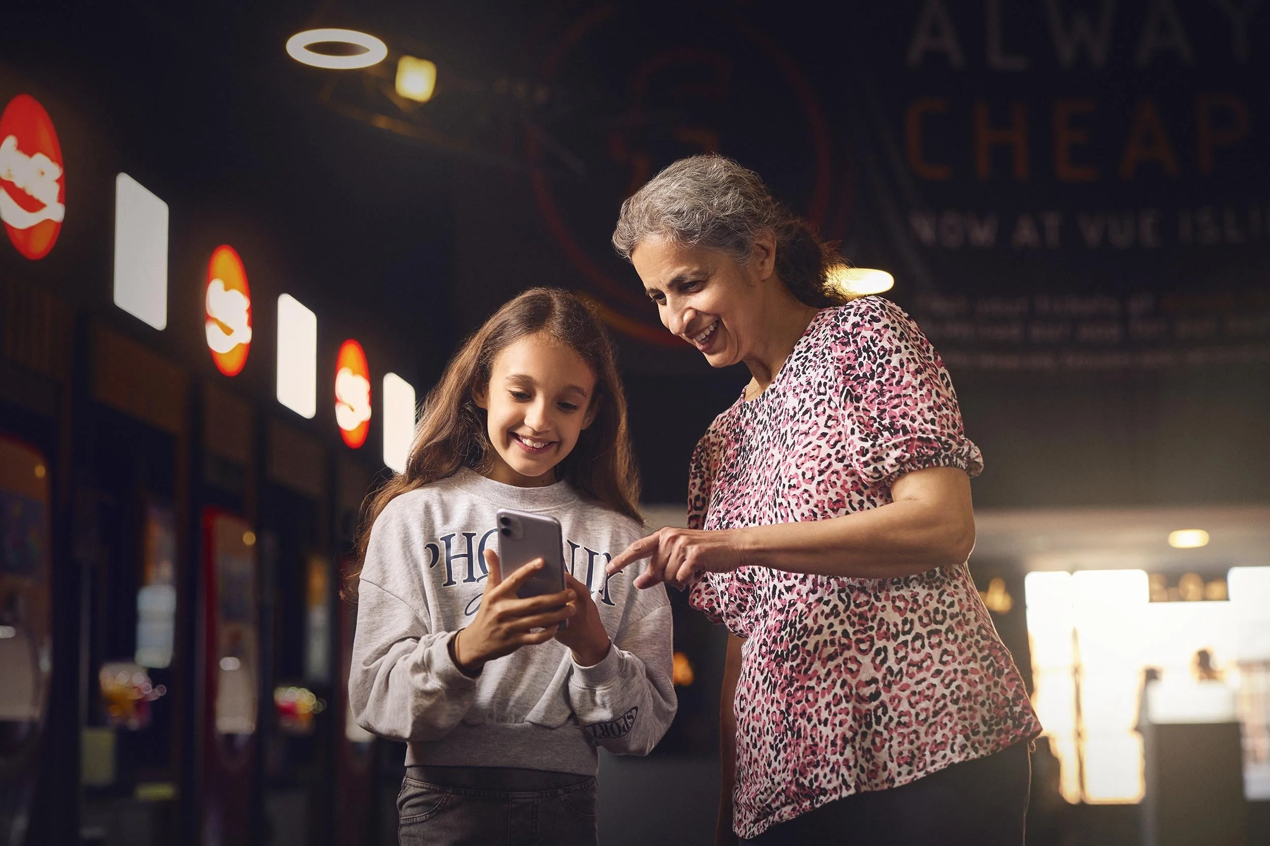 A young girl and her grandmother use their phone to access their ticket in this lifestyle photography for Vue by photographer Jon Enoch