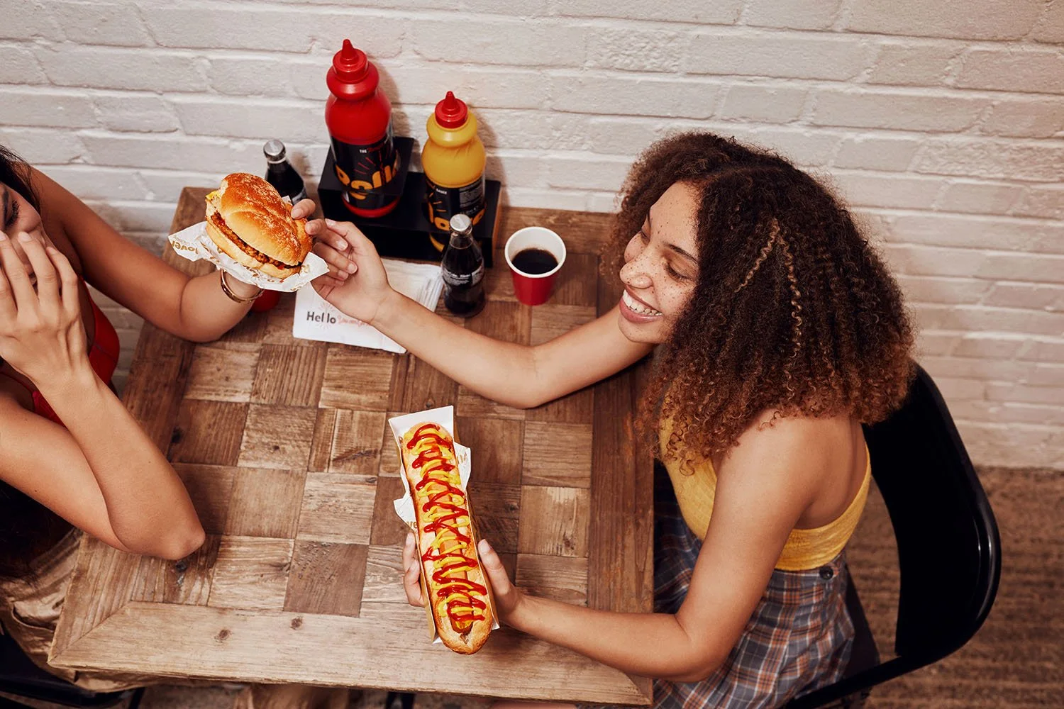 Two female friends enjoy themselves over a meal. This image was taken by lifestyle photographer Jon Enoch