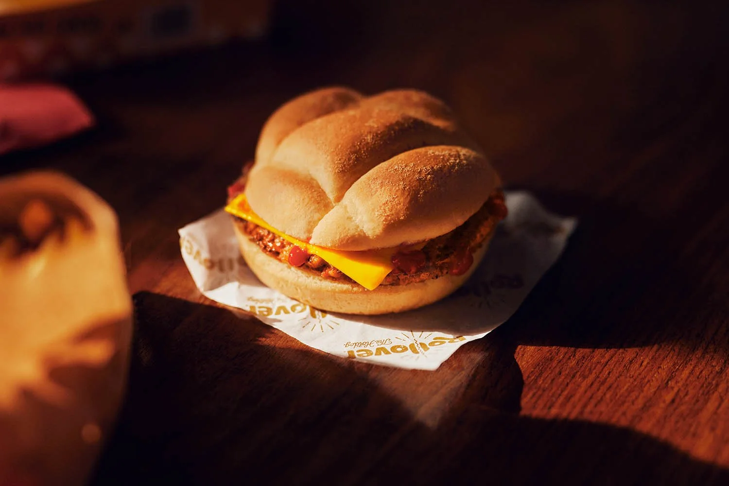A burger sits in the morning sun. Still life image by photographer Jon Enoch