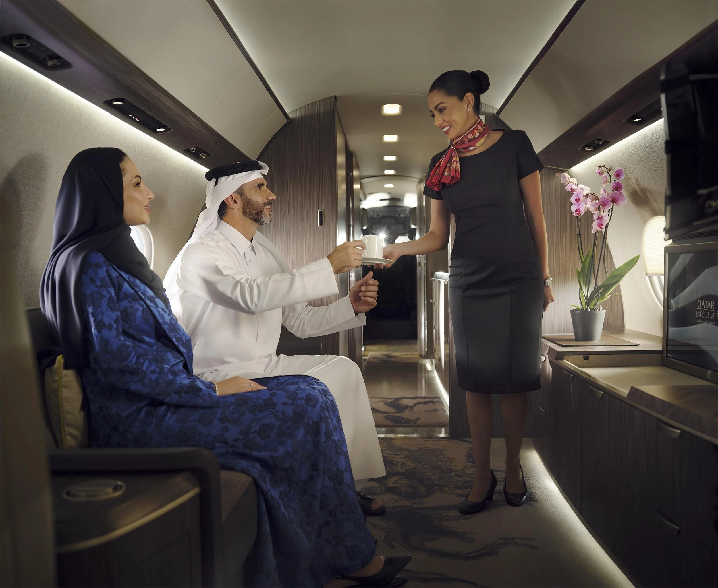 A Qatari couple are serves drinks onboard a Qatar Airways private jet in this lifestyle image by photographer Jon Enoch shot in Doha