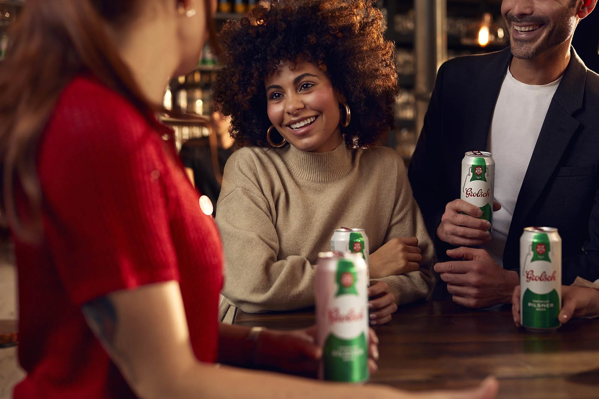 A young women chats to her friends who are all enjoying a drink in this advertising image by award winning photographer Jon Enoch