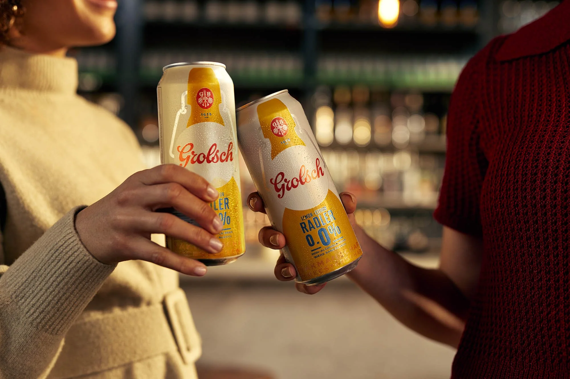 Two friends cheers their cans of zero percent beer together in this lifestyle photography by Jon Enoch