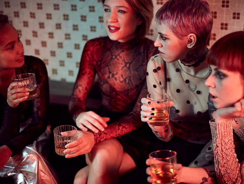 A group of young women enjoy a chat and a drink during a night out by lifestyle photographer Jon Enoch