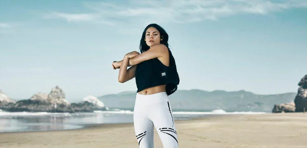 A women stretches before a work out on the beach in California. Photography by Jon Enoch who works as a advertising photographer.