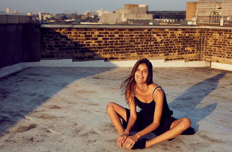 A women sits on the floor of a rooftop in central london - lifestyle photography by Jon Enoch
