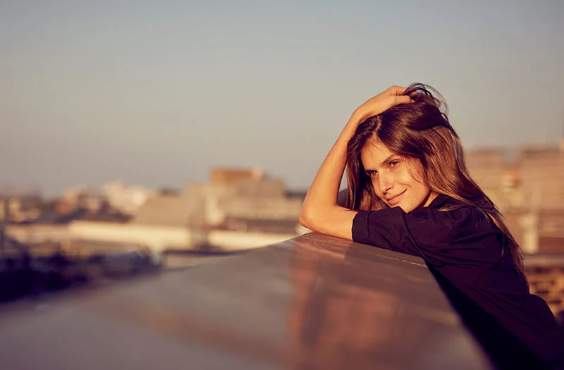 A young women looks out across the City of London as the sun sets. Lifestyle photography from London based photographer Jon Enoch