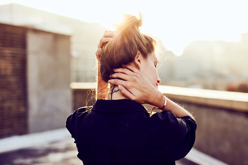 Lifestyle photography by Jon Enoch shows a women enjoying the sunset from a rooftop in Shoreditch