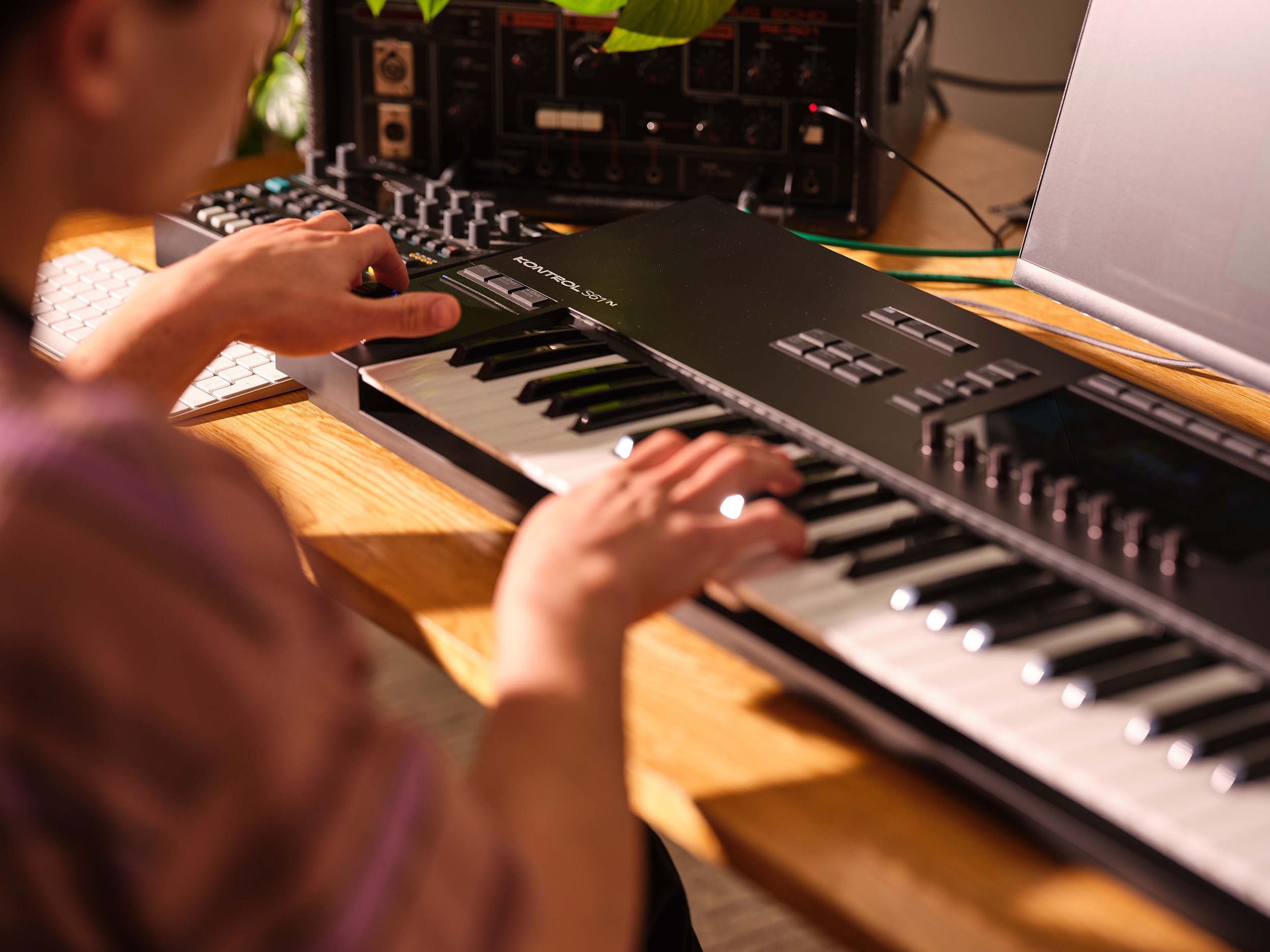 The hands of a man play a Native Instruments keyboard in this photoshoot by Jon Enoch