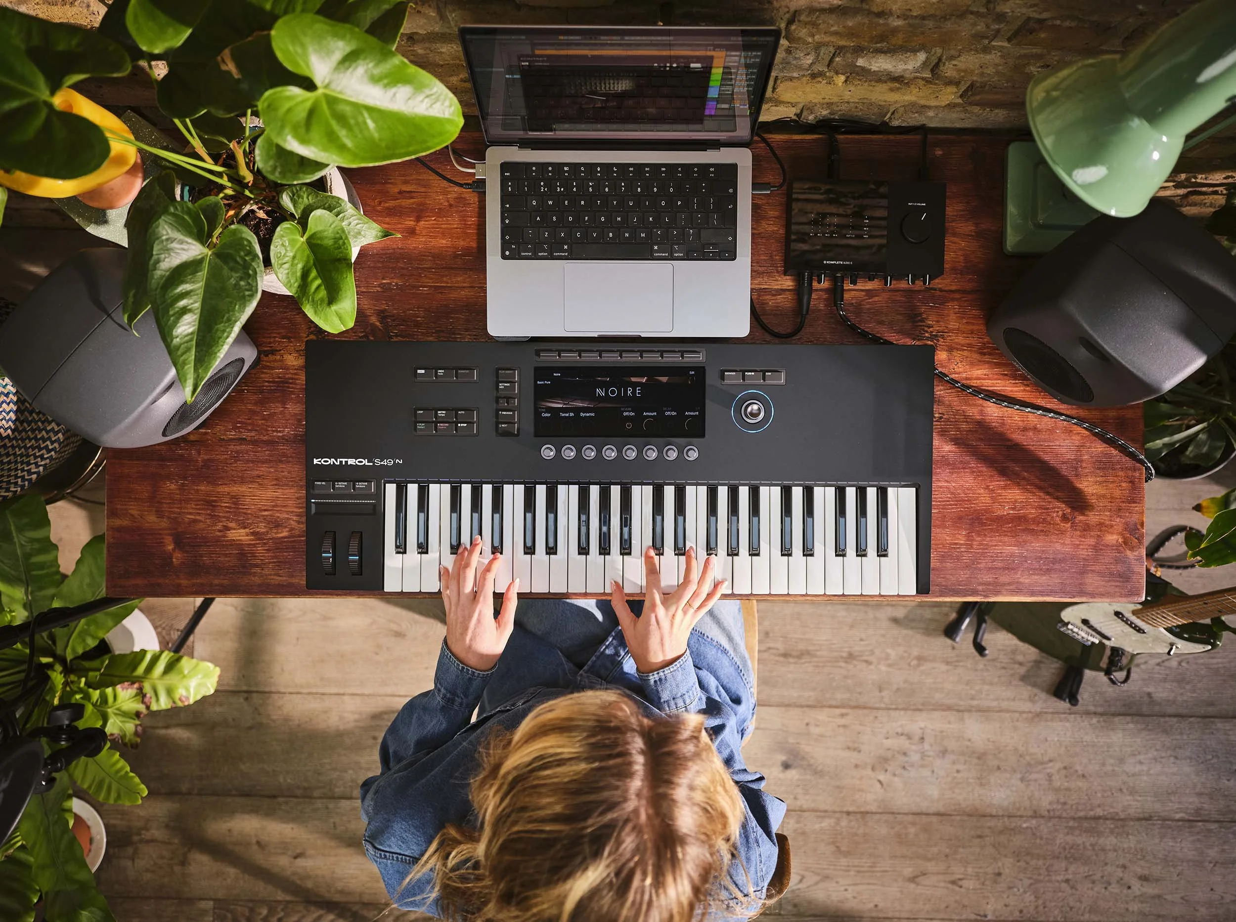 A women makes music at home pictured in this lifestyle image playing keyboards in her home recording setup