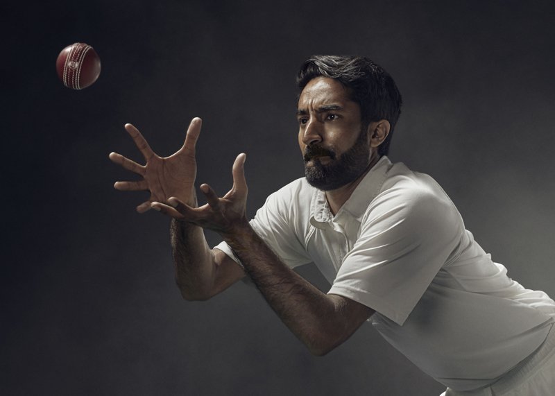 A cricket player catches the ball, hands open in this studio advertising shot by advertising photographer Jon Enoch