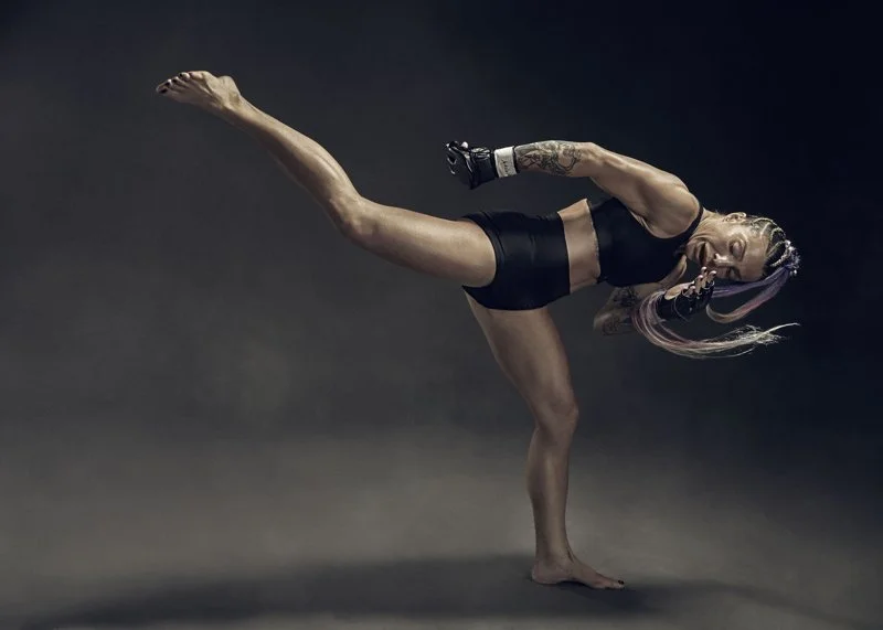 A female MMA fighter performs a high kick. Sports advertising photography by Jon Enoch