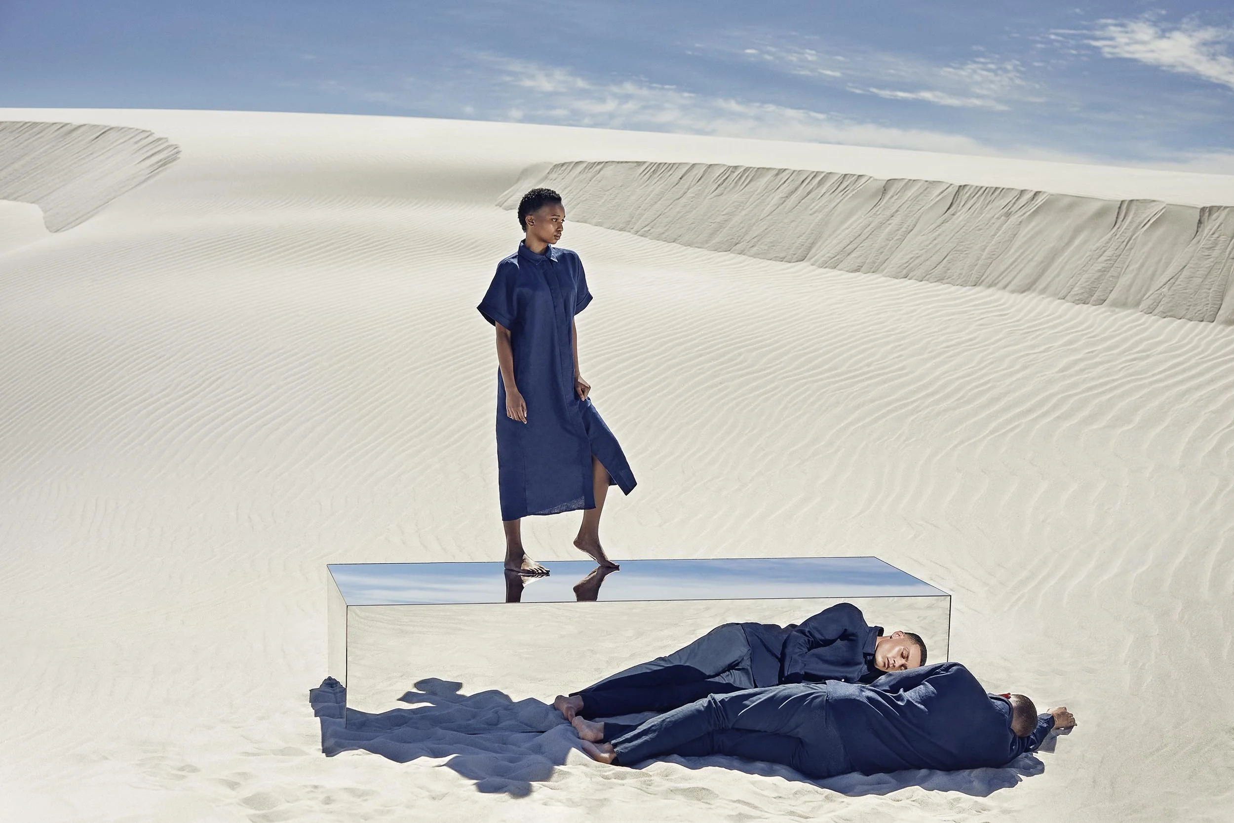 A model stands on-top of the large mirrored box in the desert in this lifestyle image by photographer Jon Enoch  (Copy)