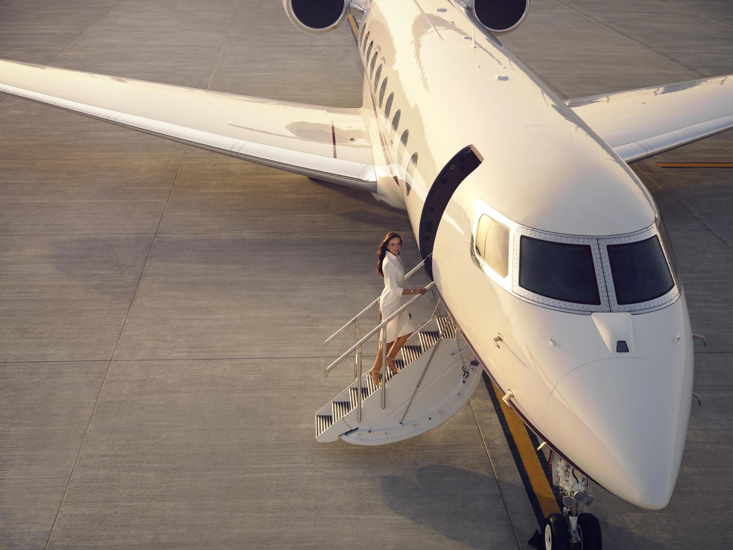 A business passenger climbs the stairs of a G700 private jet in this lifestyle image from photographer Jon Enoch   (Copy)