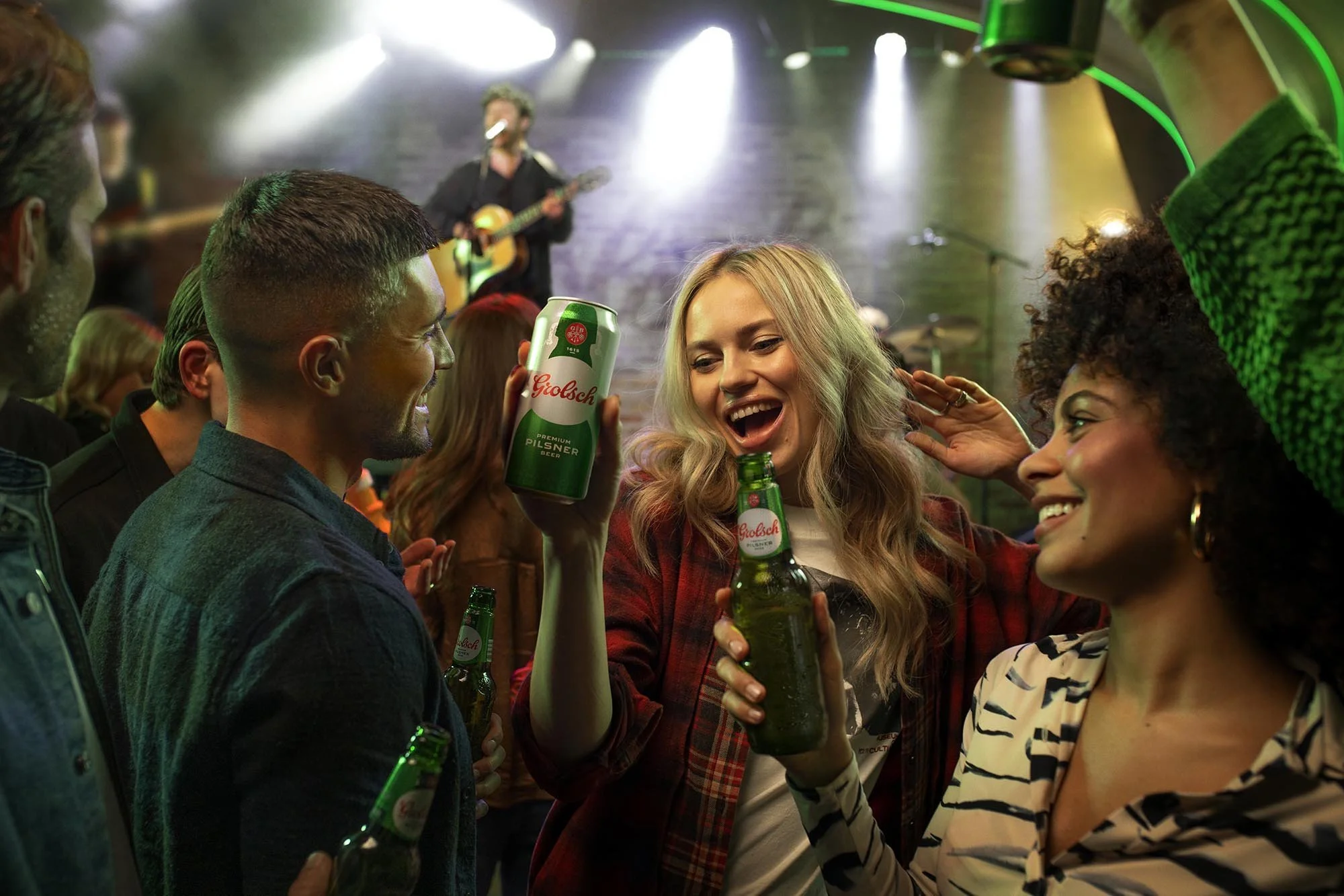 A group of friends drink beer as they watch a band in this fun lifestyle image by London based lifestyle photographer Jon Enoch