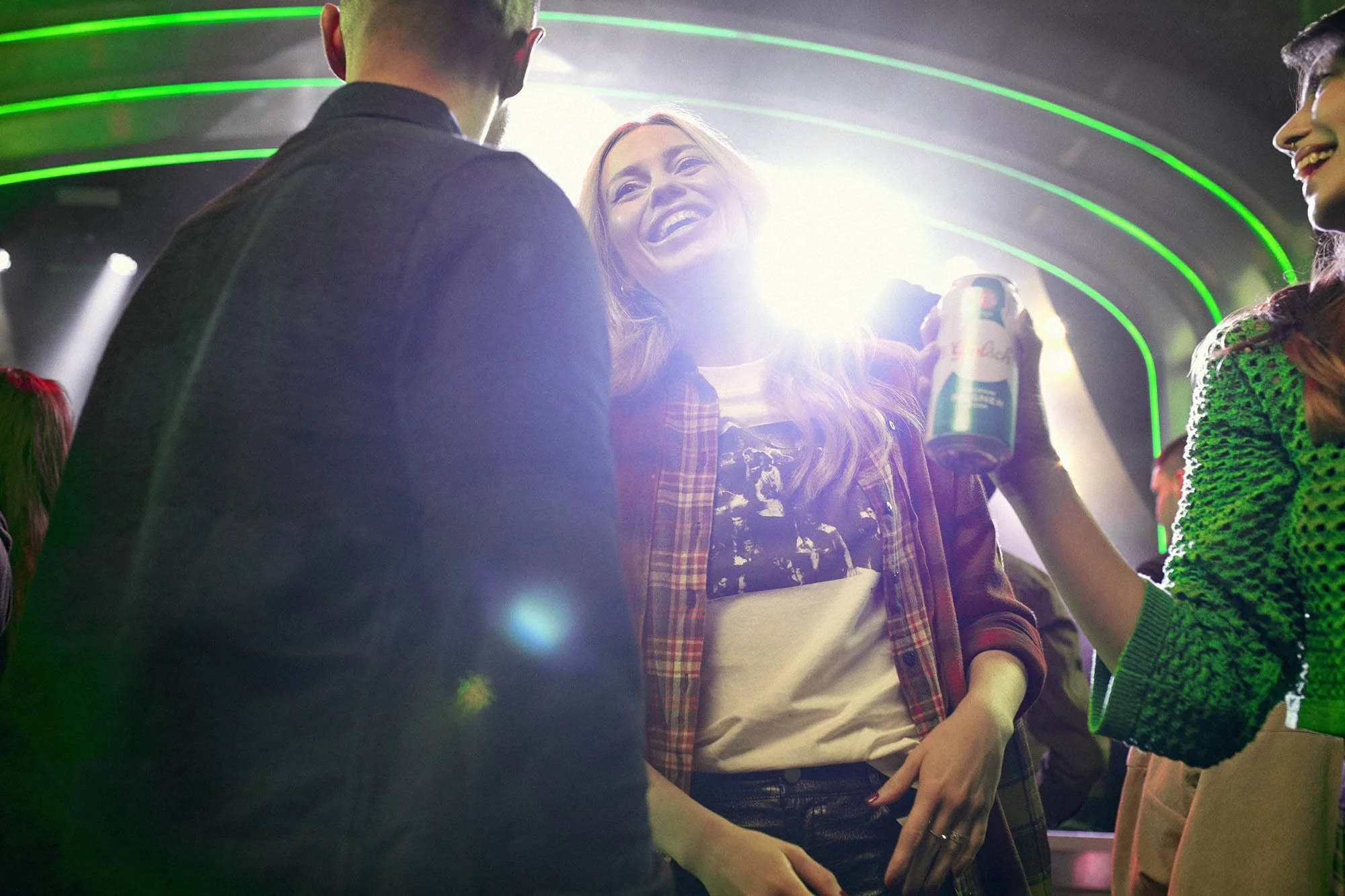 A group of friends drink beer as they watch a band in this fun lifestyle image by London based lifestyle photographer Jon Enoch