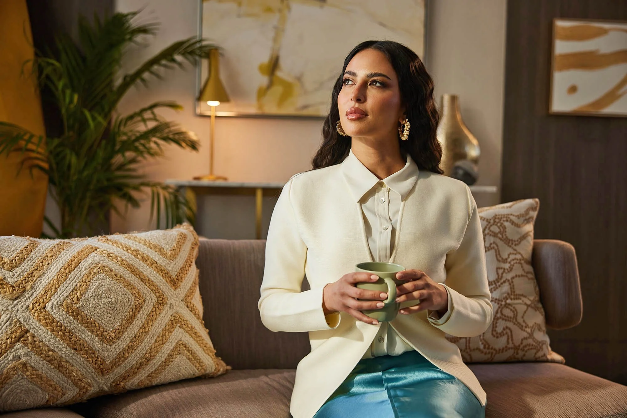 Lama Alakeel sits drinking a coffee in this advertising image by Jon Enoch shot in Saudi Arabia for the NHC.