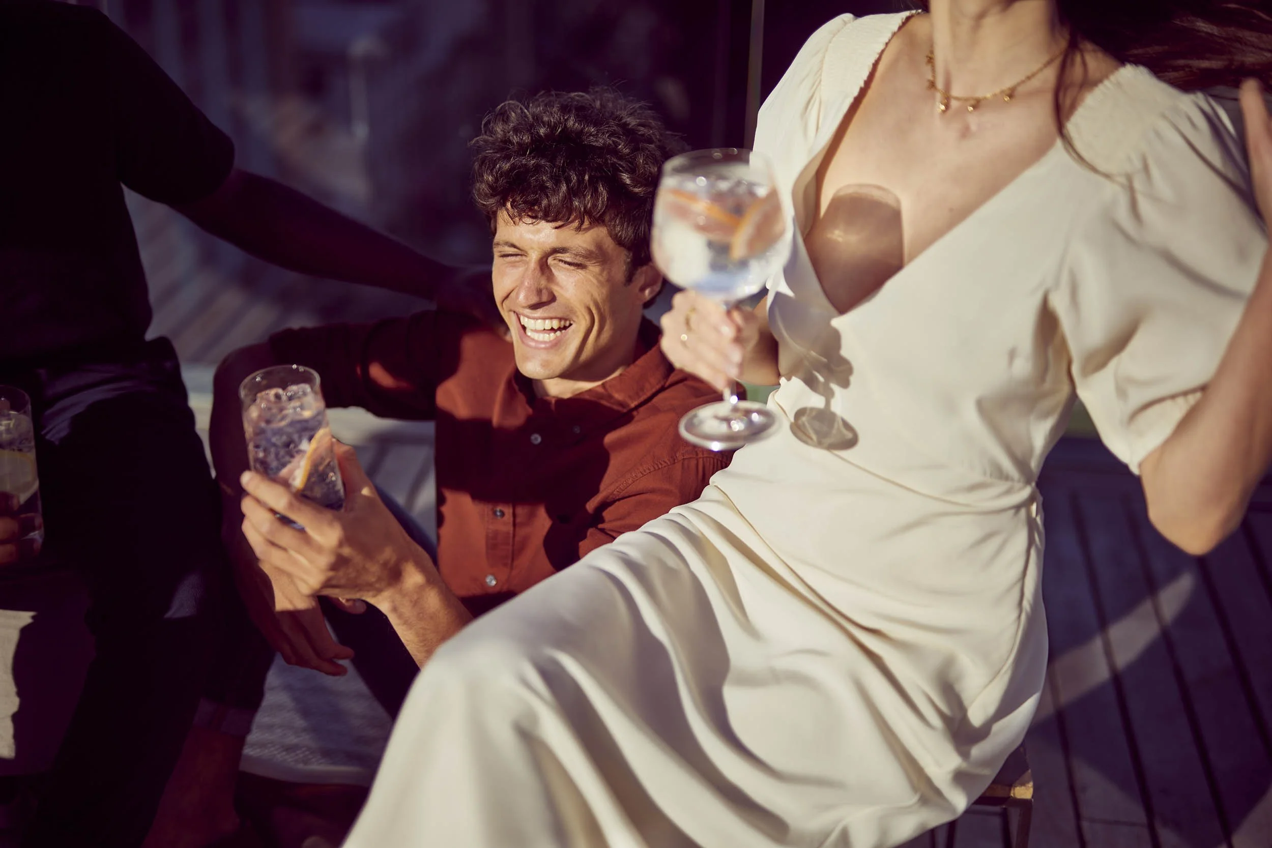 Summer drinks are enjoyed in the late afternoon sun on a rooftop in this lifestyle image by photographer Jon Enoch