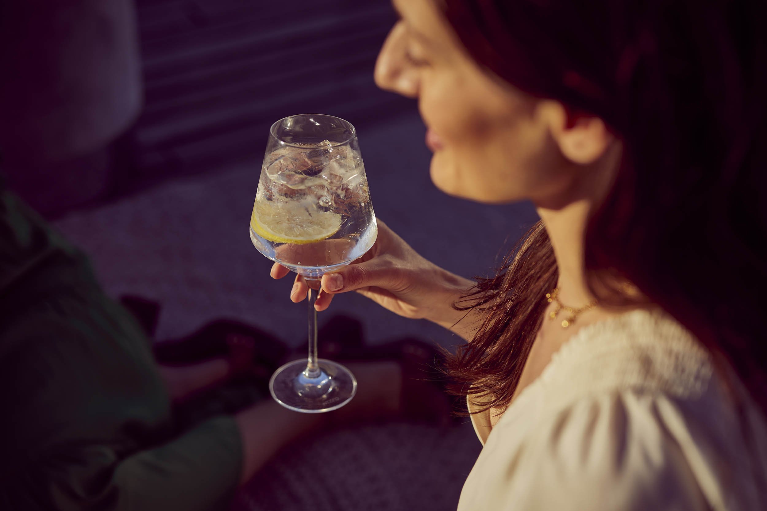 Gin a tonic - a women enjoys her drink in the summer light - lifestyle image by Jon Enoch