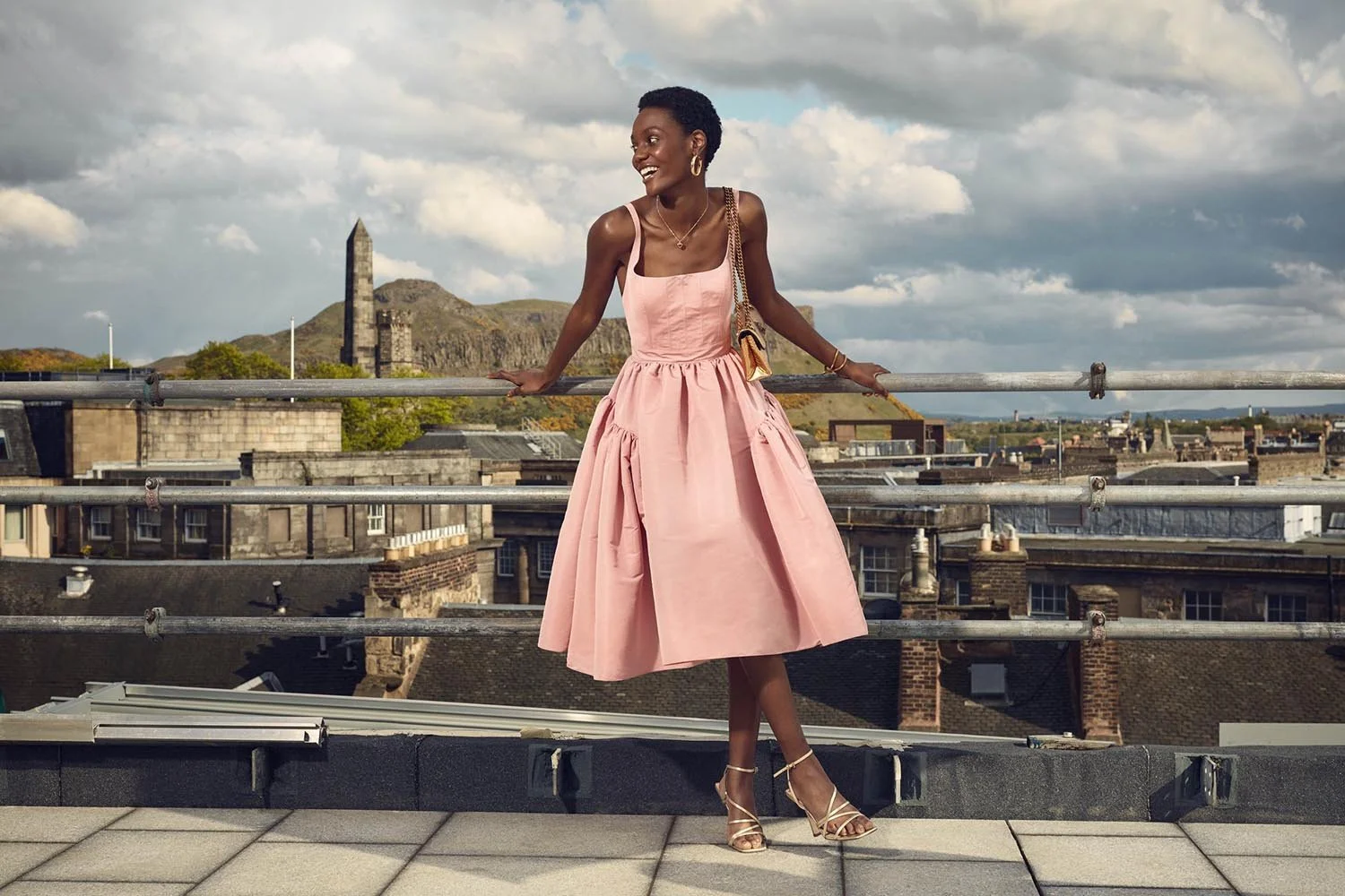 A women in a pink dress stands on top of the St.James Quater. Advertising image by Jon Enoch