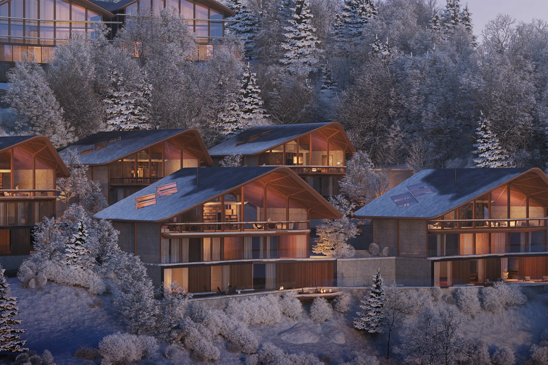 Conjunto de cabañas de madera en una ladera nevada rodeadas de árboles nevados y bosque, con ventanas iluminadas por la noche.