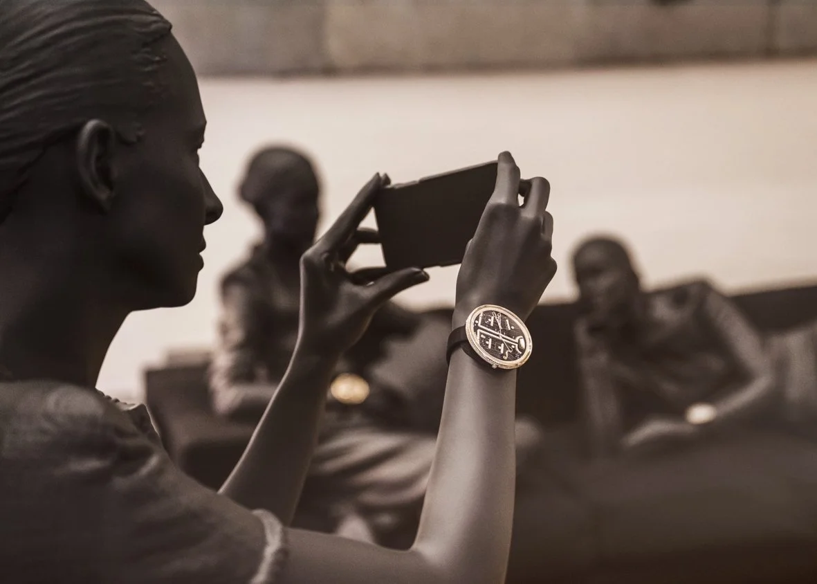 Une femme prend une photo avec son téléphone dans un groupe où d'autres personnes discutent.