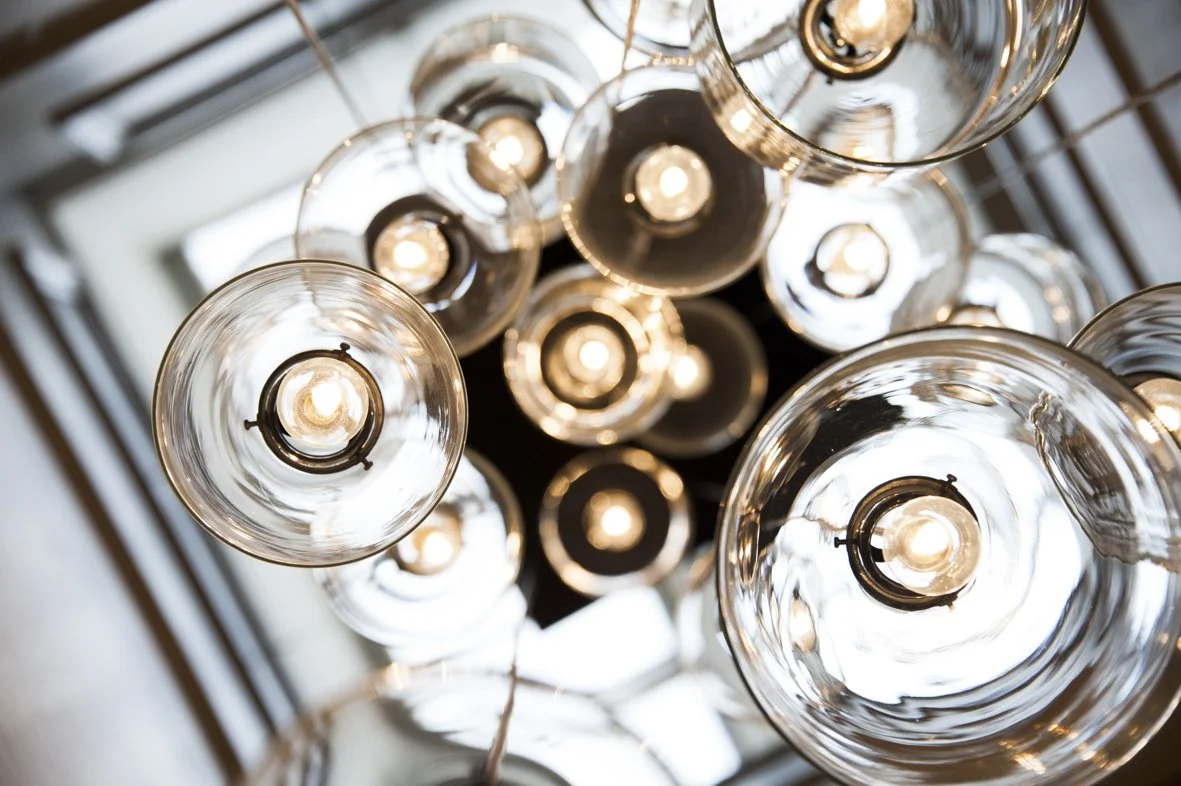 Vues du dessous de plusieurs lampes suspendues avec ampoules visibles, éclairant un plafond et créant un motif lumineux.