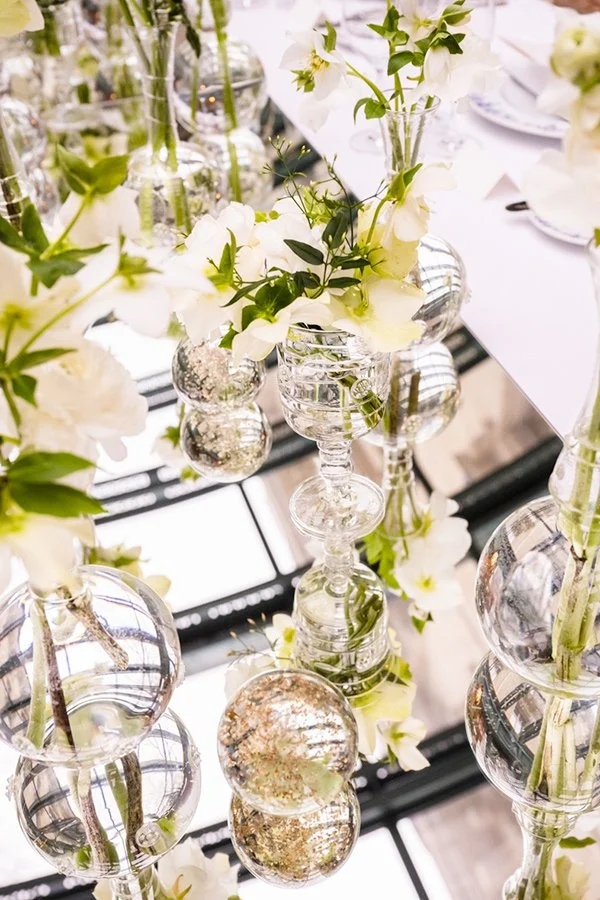 Vases en verre contenant des fleurs blanches, disposés sur une table pour une décoration élégante.