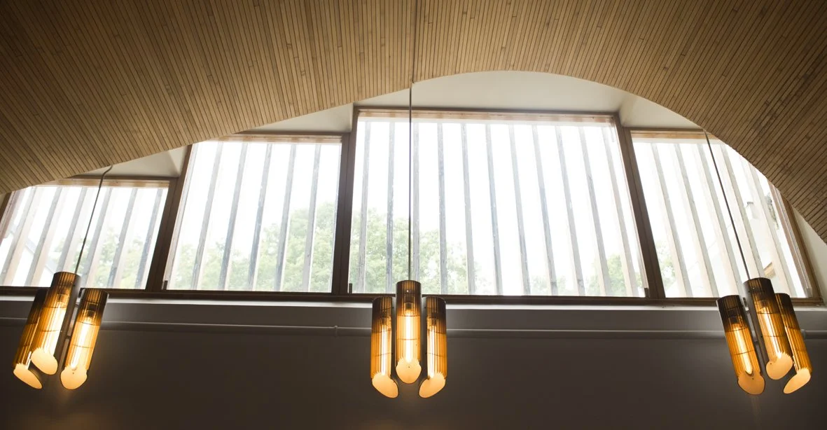 Vitrail et fenêtres dans un bâtiment moderne avec un plafond en bois et suspension lumineuse