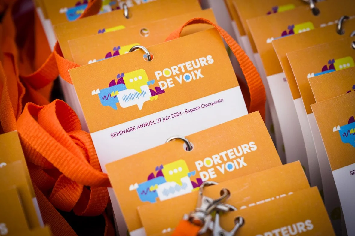 Des badges orange avec le texte 'PORTEURS DE VOIX' et une illustration colorée de bulles et de visages, disposés en rangée