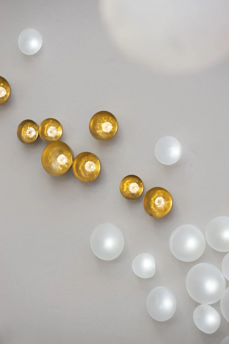 Guirlande de boules décoratives or et blanches suspendues au plafond.