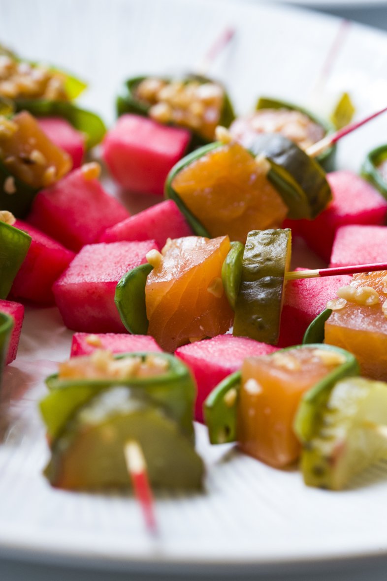 Brochettes de légumes colorés, avec du concombre, de la carotte et du radis, piquées avec des bâtonnets en bois, sur une assiette